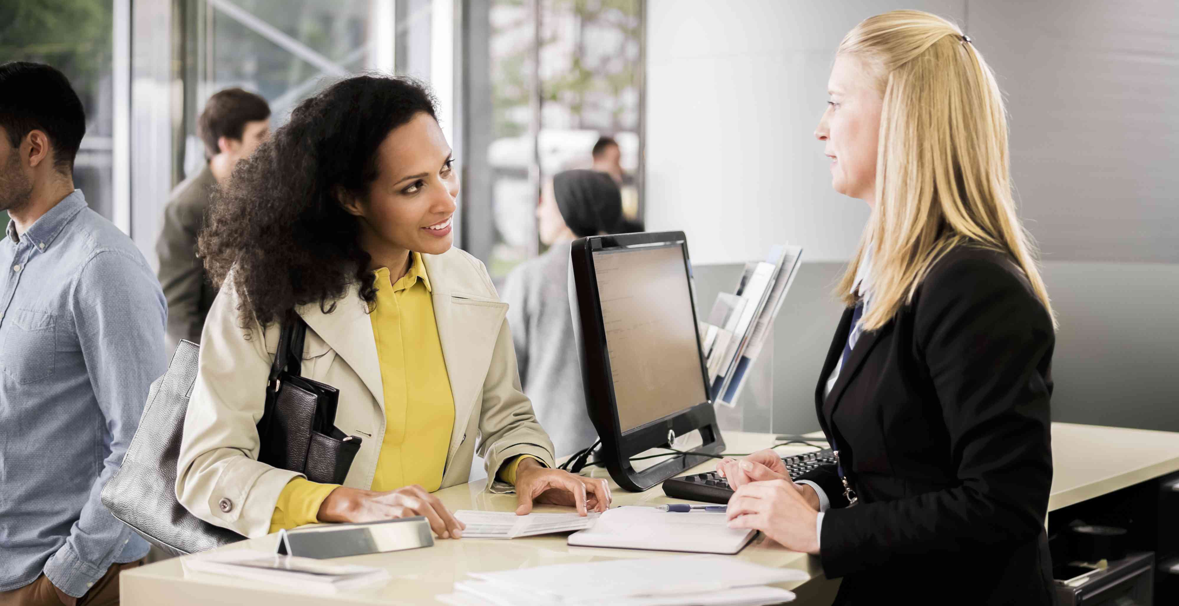 smiling woman talking with a bank teller