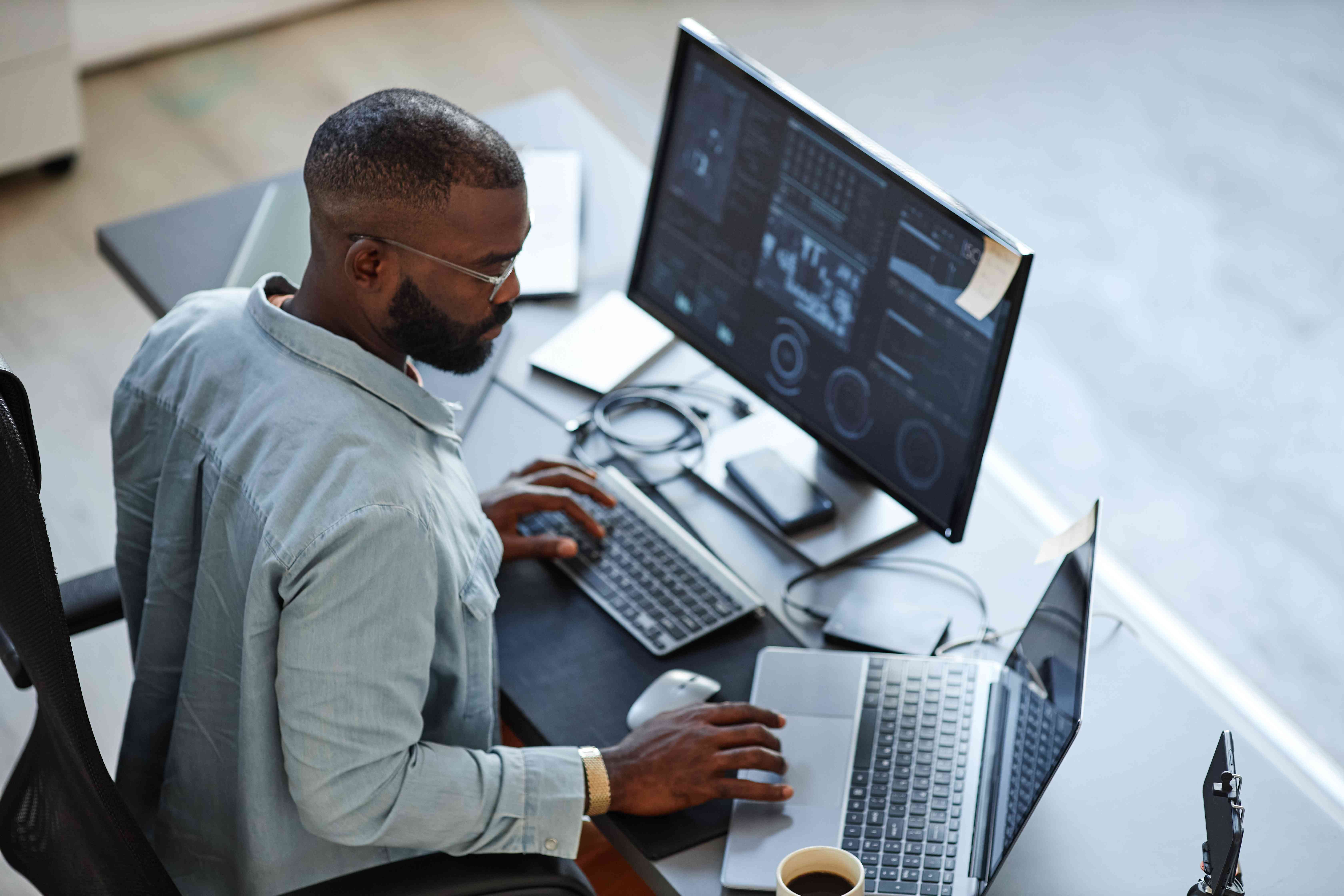 Man working with two open computer screens